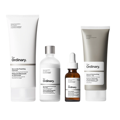 The Ordinary Refine & Regenerate Collection packaging showcasing four full-size products: Glucoside Foaming Cleanser, Saccharomyces Ferment 30% Milky Toner, GF 15% Solution, and Natural Moisturizing Factors + HA.
