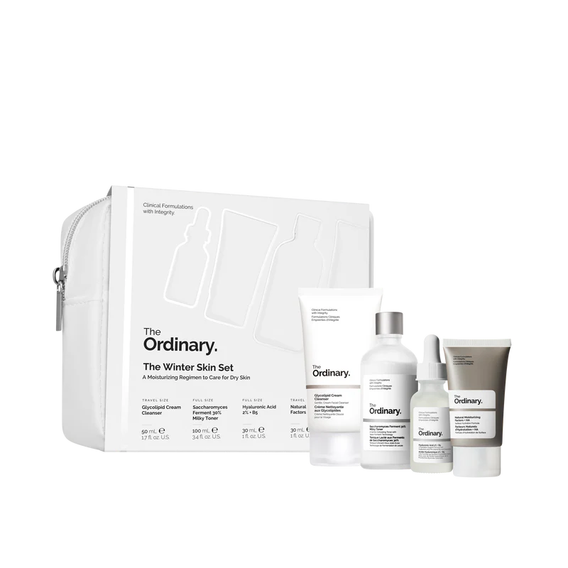 The Ordinary Winter Skin Set featuring Glycolipid Cream Cleanser, Saccharomyces Ferment 30% Milky Toner, Hyaluronic Acid 2% + B5, and Natural Moisturizing Factors + HA in a sleek, travel-friendly pouch.